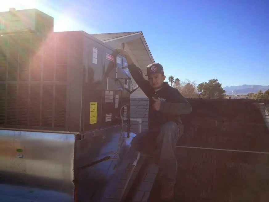 HVAC technician performing AC Tune-Up on a rooftop unit in Kaufman